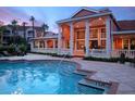 Inviting pool with elegant clubhouse featuring columns and expansive windows at sunset at 4178 Central Sarasota Pkwy # 326, Sarasota, FL 34238