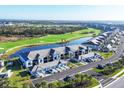 Scenic aerial view of community featuring lush golf course, pond and well-maintained residential buildings at 12470 Wellen Golf St # 203, Venice, FL 34293