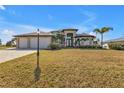 Two-story house with a three-car garage and nicely landscaped lawn at 13449 Palau Cir, Port Charlotte, FL 33953