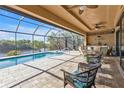 Large screened-in pool and patio area with seating at 13449 Palau Cir, Port Charlotte, FL 33953