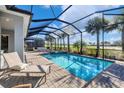 Relaxing pool and patio area with covered lanai, spa, and lush landscaping at 25223 Keygrass Ct, Punta Gorda, FL 33955