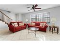 Living room with red couches, coffee table, and tiled floor at 3335 Purple Martin Dr # 1, Punta Gorda, FL 33950