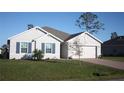 Single-story home with gray siding, blue shutters, and a paved driveway at 16031 Alcira Cir, Punta Gorda, FL 33955
