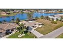 Exterior view of waterfront home with lush landscaping, mature palm trees, and a private screened lanai at 2321 Sofia Ln, Punta Gorda, FL 33983