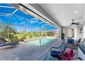 Screened-in pool area with lounge chairs and patio furniture at 386 Royal Poinciana, Punta Gorda, FL 33955