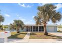 Light blue single story home with palm trees and screened porch at 174 Severin Se Rd, Port Charlotte, FL 33952