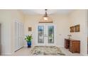 Bright entryway with double doors, wood desk, and a large plant at 3818 Bordeaux Dr, Punta Gorda, FL 33950