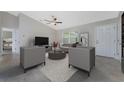 Spacious living room showcasing contemporary furniture, an ceiling fan and neutral tones at 6356 Opa Locka Ln, North Port, FL 34291