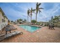 Community pool with lounge chairs, tables, and palm trees at 17094 Acapulco Rd # 313, Punta Gorda, FL 33955