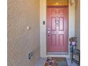 Red front door with a welcome mat, adding a touch of charm to the entryway at 25017 Lalique Pl, Punta Gorda, FL 33950