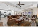 Spacious living room with a brown sofa and large windows at 42154 Journey Dr, Punta Gorda, FL 33982