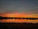 Sunset view over calm lake with houses visible in the background at 7021 Waterford Pkwy, Punta Gorda, FL 33950