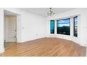 Spacious living room featuring wood flooring, bay windows, and ample natural light at 10129 Edmonton Ave, Englewood, FL 34224