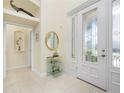 Bright entryway with tiled floors, a glass-top table, and a white door at 1110 Rum Cay Ct, Punta Gorda, FL 33950