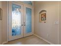 Elegant entryway with glass double doors and niche at 13761 Long Lake Ln, Port Charlotte, FL 33953