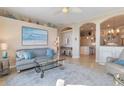 Bright living room featuring neutral walls, comfortable seating, and arched doorways leading to the kitchen at 13761 Long Lake Ln, Port Charlotte, FL 33953