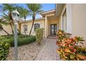 Landscaped entryway with a brick walkway leading to the front door at 1531 Aqui Esta Dr # 1, Punta Gorda, FL 33950