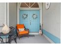 Front porch with blue doors, orange chair, and wreaths at 16253 Cape Horn Blvd, Punta Gorda, FL 33955