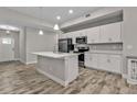 Modern kitchen featuring white cabinets, stainless steel appliances, and an island at 18322 Garman Ave, Port Charlotte, FL 33948