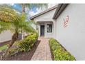 Front entry with a brick walkway and well-manicured landscaping at 19119 Mangieri St, Venice, FL 34293