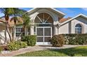 House exterior featuring a screened entryway and lush landscaping at 2210 Bengal Ct, Punta Gorda, FL 33983