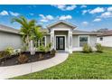 Landscaped front yard with walkway leading to modern front door at 2380 Ann Arbor Rd, North Port, FL 34286