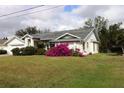 Single-story house with a spacious lawn and flowering bushes at 27446 Pasto Dr, Punta Gorda, FL 33983