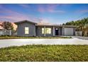 Charming gray house with a modern facade, well-manicured lawn, and a two-car garage at 3112 Magnolia Way, Punta Gorda, FL 33950