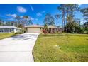 House exterior with a driveway and lush green lawn at 4198 Kinlock St, North Port, FL 34286