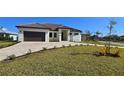 Modern single-story home with a two-car garage and landscaped lawn at 432 Gun Cay Ln, Punta Gorda, FL 33950