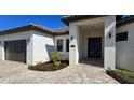 Modern home's front entrance with covered porch and paver walkway at 432 Gun Cay Ln, Punta Gorda, FL 33950