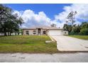 Single-story home with a spacious driveway and well-maintained lawn at 4401 Boeing Ln, North Port, FL 34287