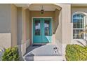 Inviting teal front door with glass panels and a small porch at 45 Marker Rd, Rotonda West, FL 33947