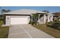 Light gray house with a white garage door and a nicely landscaped yard at 4607 Sabrina Ter, North Port, FL 34286