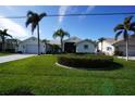 Front view of a house with a landscaped yard and palm trees at 506 Monaco Dr, Punta Gorda, FL 33950