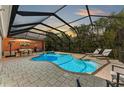 Inviting screened pool area with lounge chairs and outdoor kitchen at 668 W Olympia Ave, Punta Gorda, FL 33950