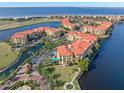 Aerial view of waterfront community with resort-style pool and tennis courts at 98 Vivante Blvd # 98317, Punta Gorda, FL 33950