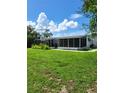 Large backyard with screened enclosure and lush grass at 158 Concord Ne Dr, Port Charlotte, FL 33952