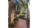 Brick walkway with tropical landscaping, leading to condo entrance at 23465 Harborview Rd # 1006, Punta Gorda, FL 33980