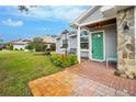 Inviting front porch with a teal door and brick walkway at 238 Woodingham Trl, Venice, FL 34292