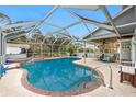 Inviting pool area with screened enclosure, spa, and patio furniture at 238 Woodingham Trl, Venice, FL 34292