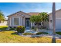 Tan house with palm trees, landscaped yard, and two-car garage at 24060 Buckingham Way, Punta Gorda, FL 33980