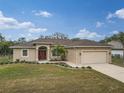 One-story house featuring a tan exterior and red door at 4557 Sabrina Ter, North Port, FL 34286