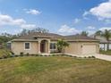 Tan house with red door, driveway and landscaping at 4557 Sabrina Ter, North Port, FL 34286