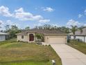 Tan one story house with red door and two car garage at 4557 Sabrina Ter, North Port, FL 34286