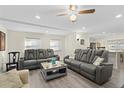 Spacious living room with comfortable gray reclining sofas and wood-look flooring at 5298 Palena Blvd, North Port, FL 34287