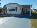 Mobile home with covered porch and a paved driveway at 6815 Amoko Ct, North Port, FL 34287