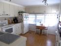 Efficient kitchen with white cabinets, appliances, and breakfast nook at 6815 Amoko Ct, North Port, FL 34287