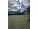 Gray house with teal accents and a large lawn at 1281 Nebraska Ln, North Port, FL 34286