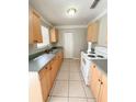 Simple kitchen with light wood cabinets and white appliances at 21061 Midway Blvd, Port Charlotte, FL 33952